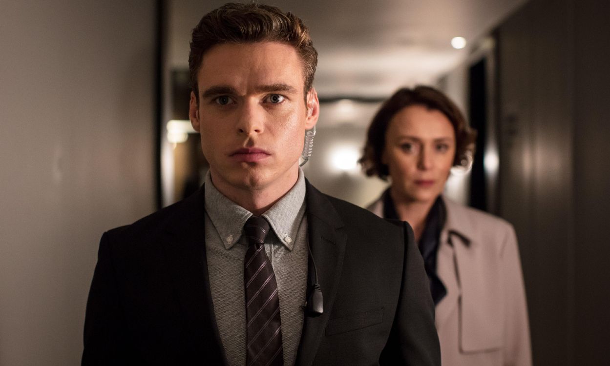 man in black suit jacket standing beside woman in black blazer