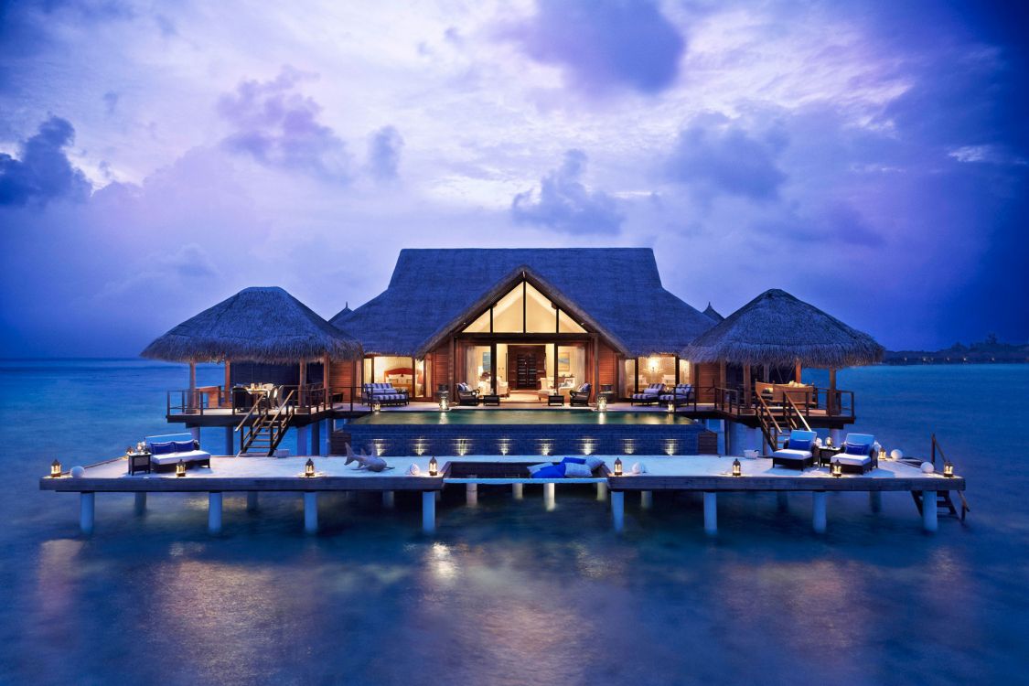 brown wooden houses on water under blue sky during daytime