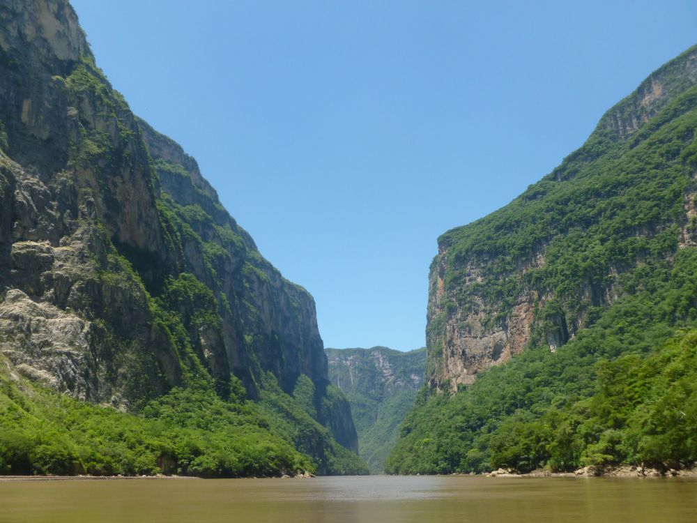 green mountain beside river during daytime