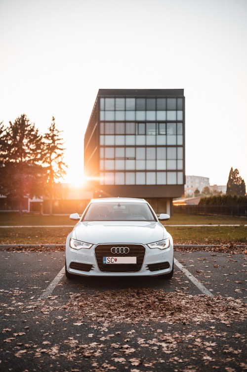 Image white audi a 4 parked on roadside near building during daytime