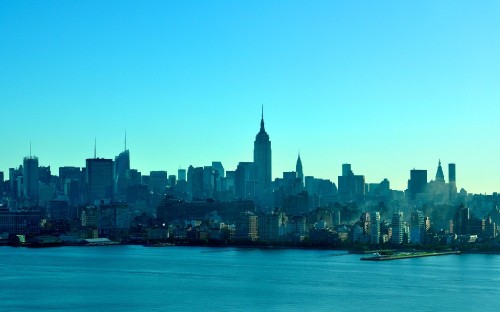 Image city skyline across body of water during daytime