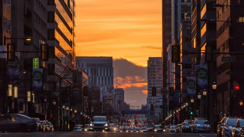 Image cars on road between high rise buildings during sunset