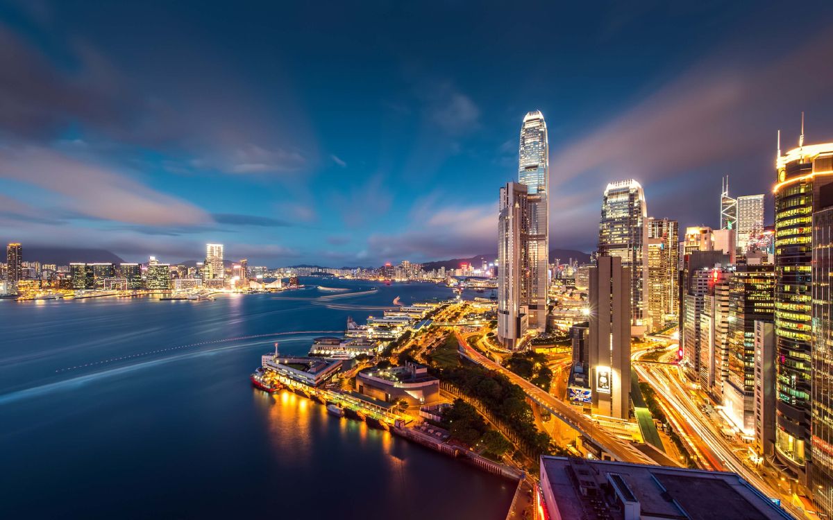 city skyline under blue sky during night time