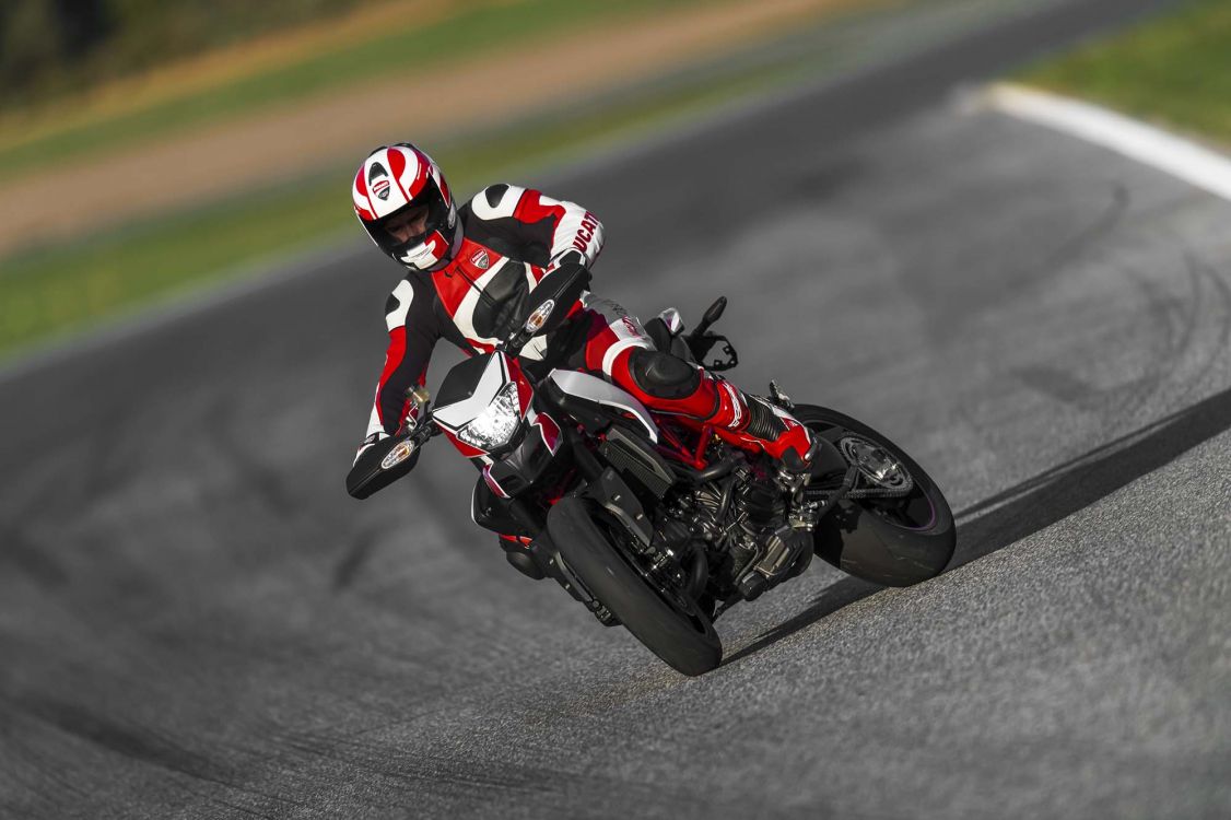 man in red and white racing suit riding on black and red sports bike