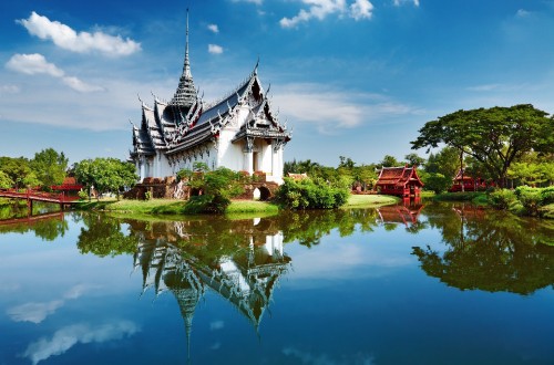 Image white and black house near body of water under blue sky during daytime