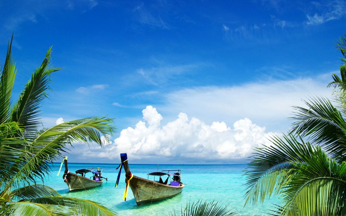 man in blue shirt riding on boat on sea under blue and white cloudy sky during