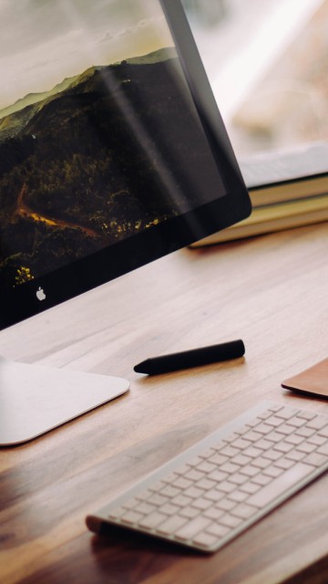 Image silver imac on brown wooden table