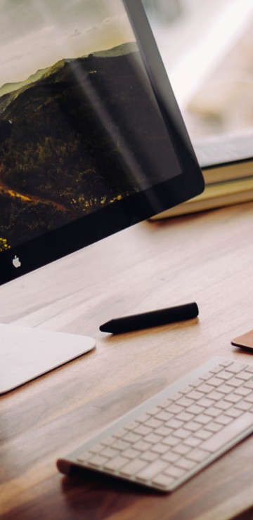 Image silver imac on brown wooden table