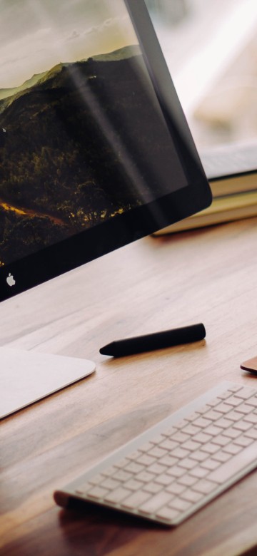Image silver imac on brown wooden table
