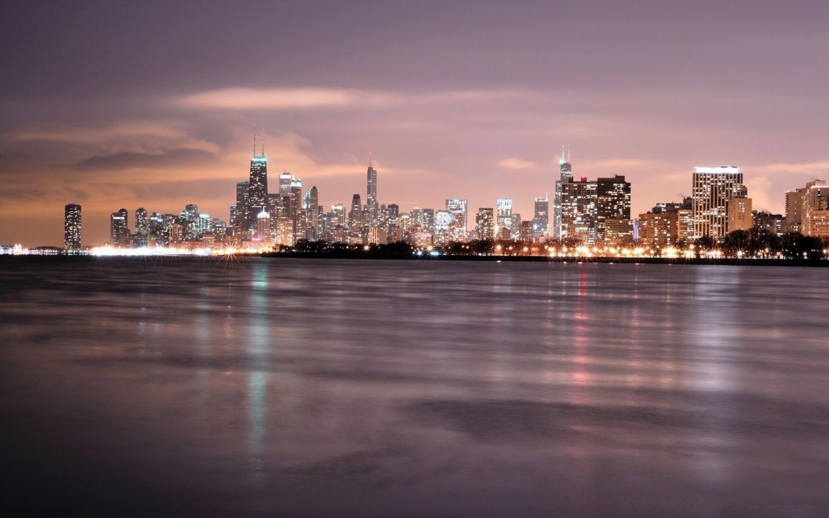 Skyline Der Stadt Über Gewässer Während Der Nacht. Wallpaper in 2560x1600 Resolution