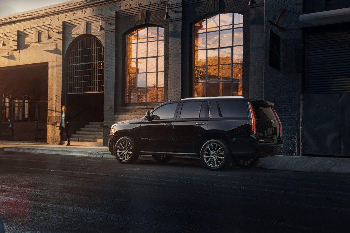 Suv Negro Estacionado Frente al Edificio Marrón. Wallpaper in 6000x4000 Resolution