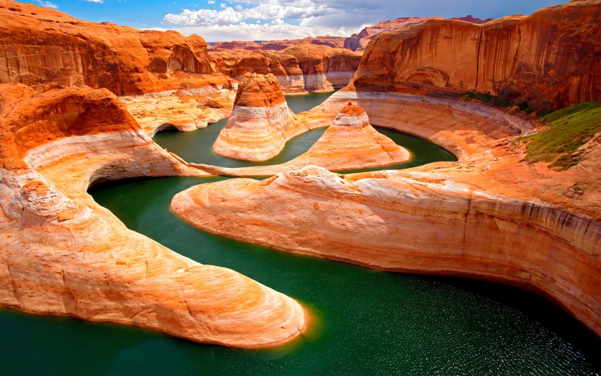 brown rock formation near green water