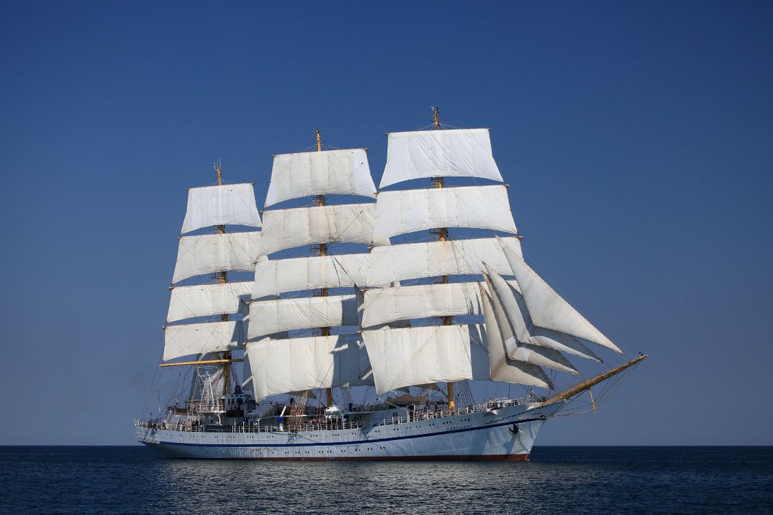 white sail boat on sea under blue sky during daytime