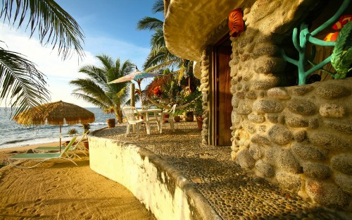 Image brown wooden chairs and table near palm trees during daytime