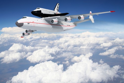 Image white and red airplane under white clouds and blue sky during daytime