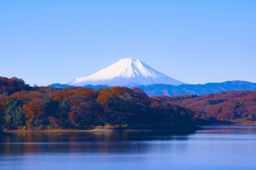 Image brown and white mountain near body of water during daytime