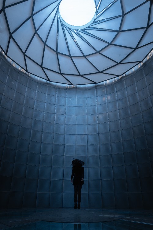 Image man in black jacket standing in front of glass wall