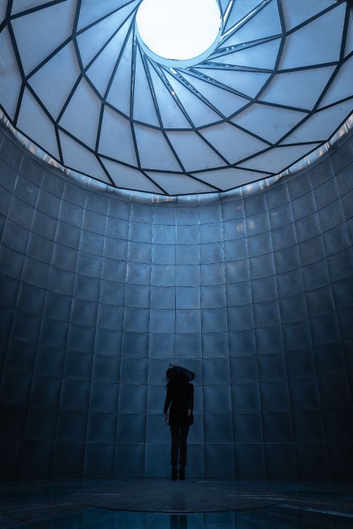 man in black jacket standing in front of glass wall