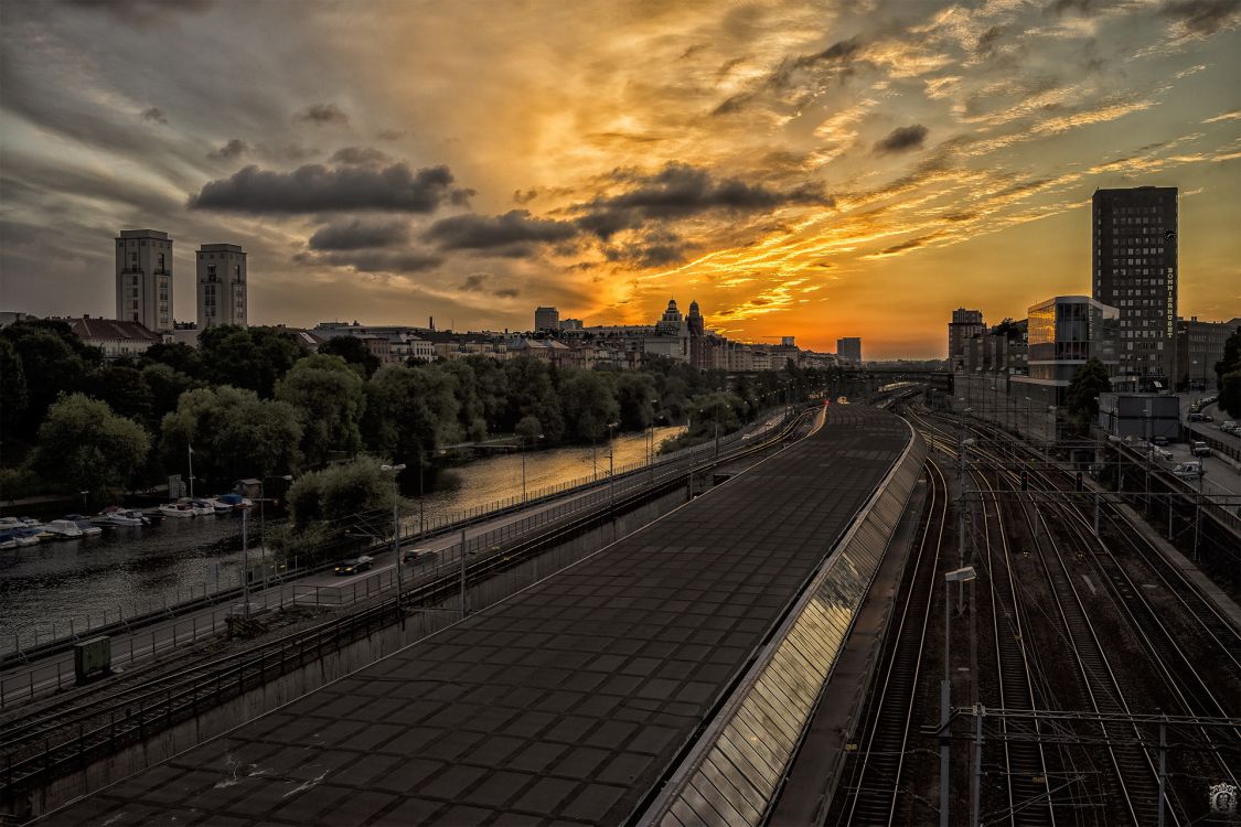 train rail near city buildings during sunset