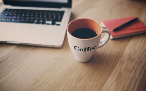 Image white ceramic mug beside macbook pro