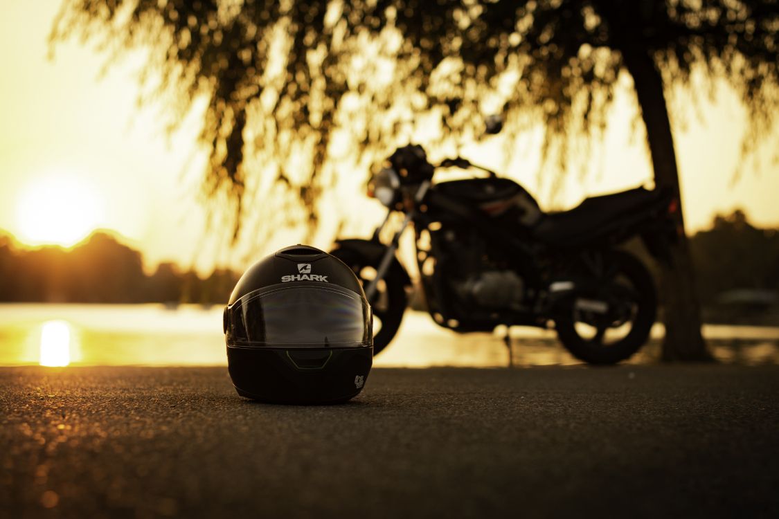 black motorcycle parked on road during daytime