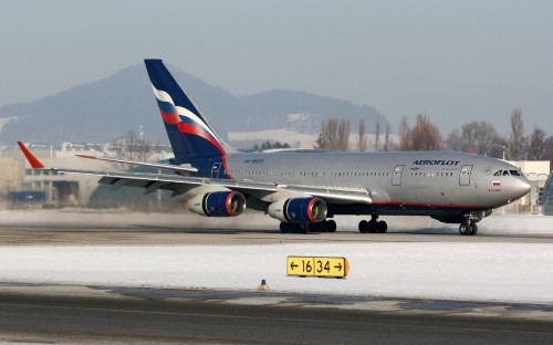 Image white and red passenger plane on airport during daytime