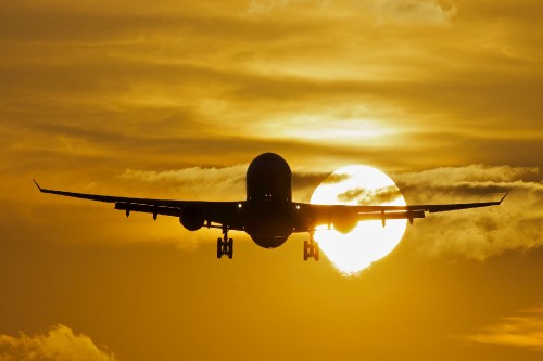 Image black airplane under cloudy sky during sunset