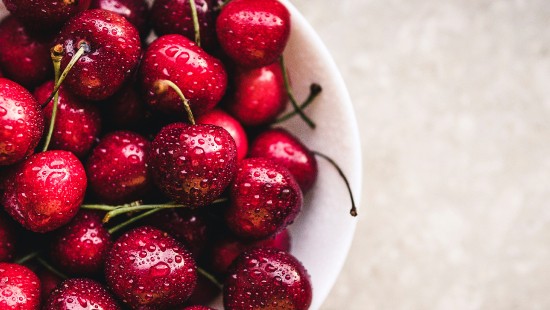 Image red cherries on white ceramic bowl