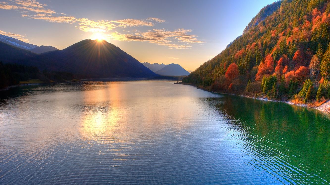 body of water near mountain during daytime