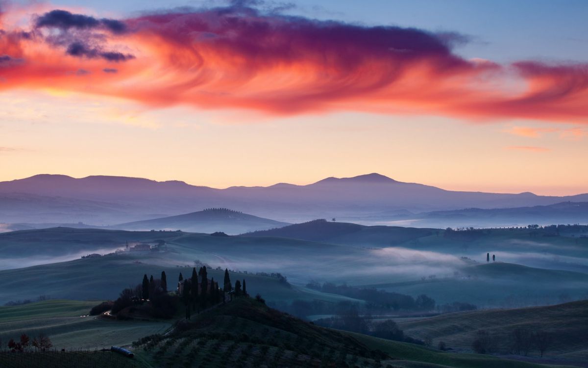 green mountains under orange sky