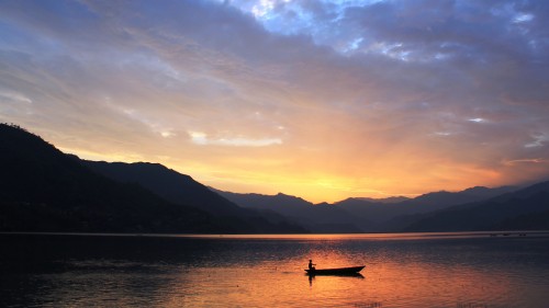 Image silhouette of 2 people riding on boat on sea during sunset