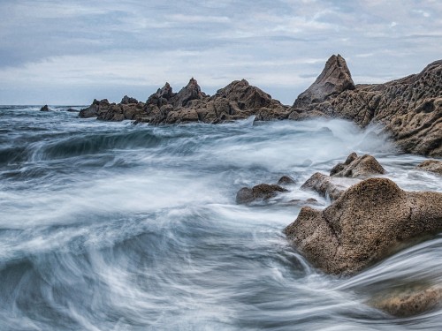 Image brown rock formation on body of water during daytime