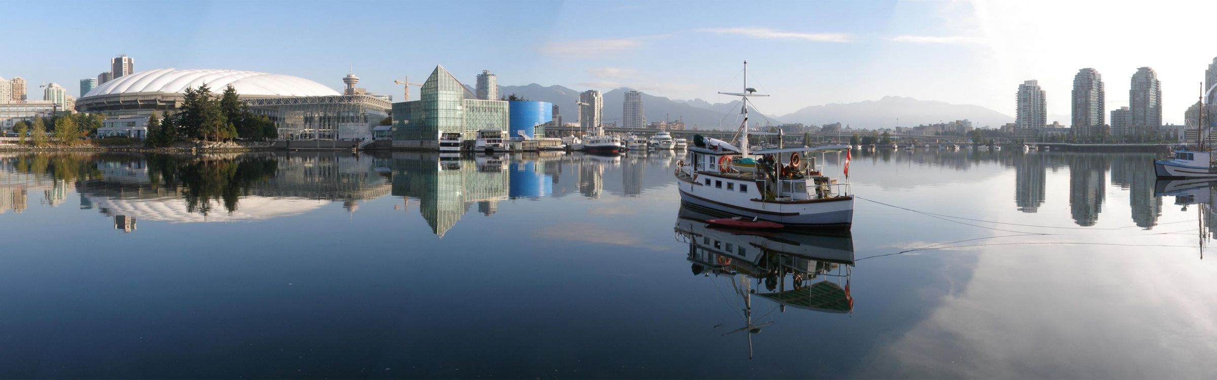 white and red boat on water near city buildings during daytime