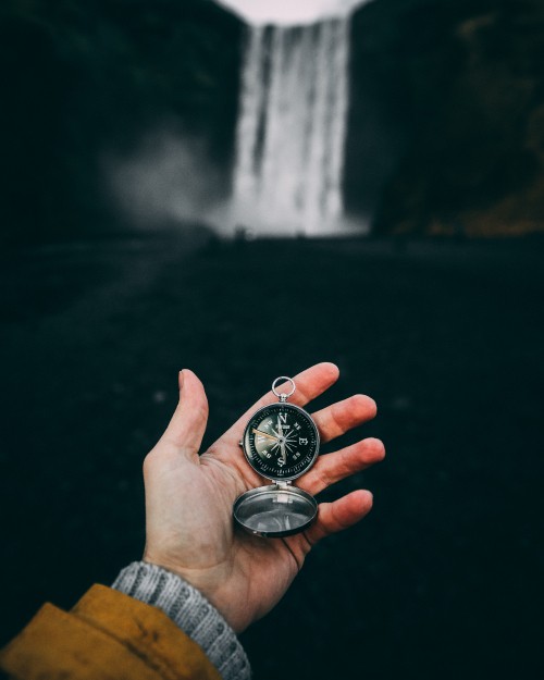 Image person holding silver round analog watch