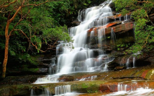 Image water falls on brown and green rock