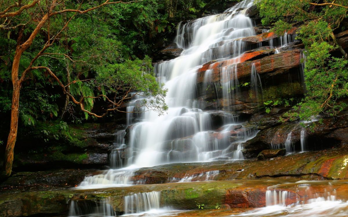 water falls on brown and green rock