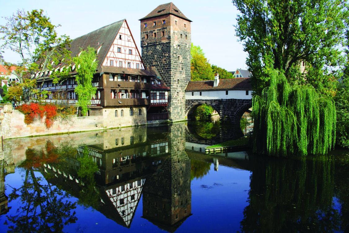 Braunes Backsteingebäude am Fluss Tagsüber. Wallpaper in 3456x2304 Resolution