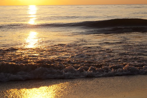 Image sea waves crashing on shore during sunset