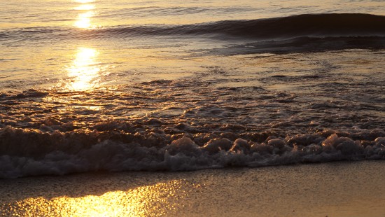 Image sea waves crashing on shore during sunset