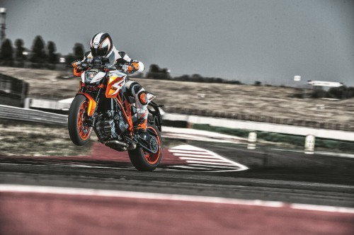 Image man in black and orange motorcycle suit riding on orange and black sports bike