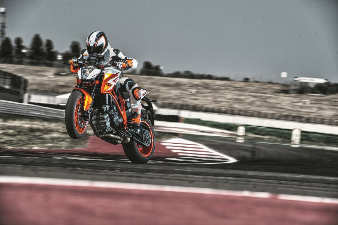 Homme en Costume de Moto Noir et Orange à Cheval Sur un Vélo de Sport Orange et Noir. Wallpaper in 3600x2396 Resolution