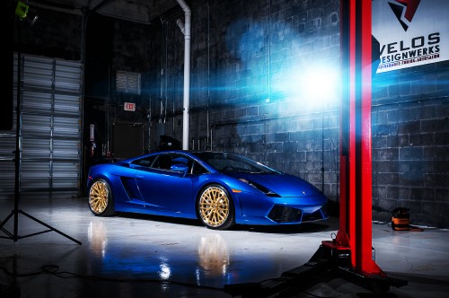 Image blue porsche 911 parked in front of glass building