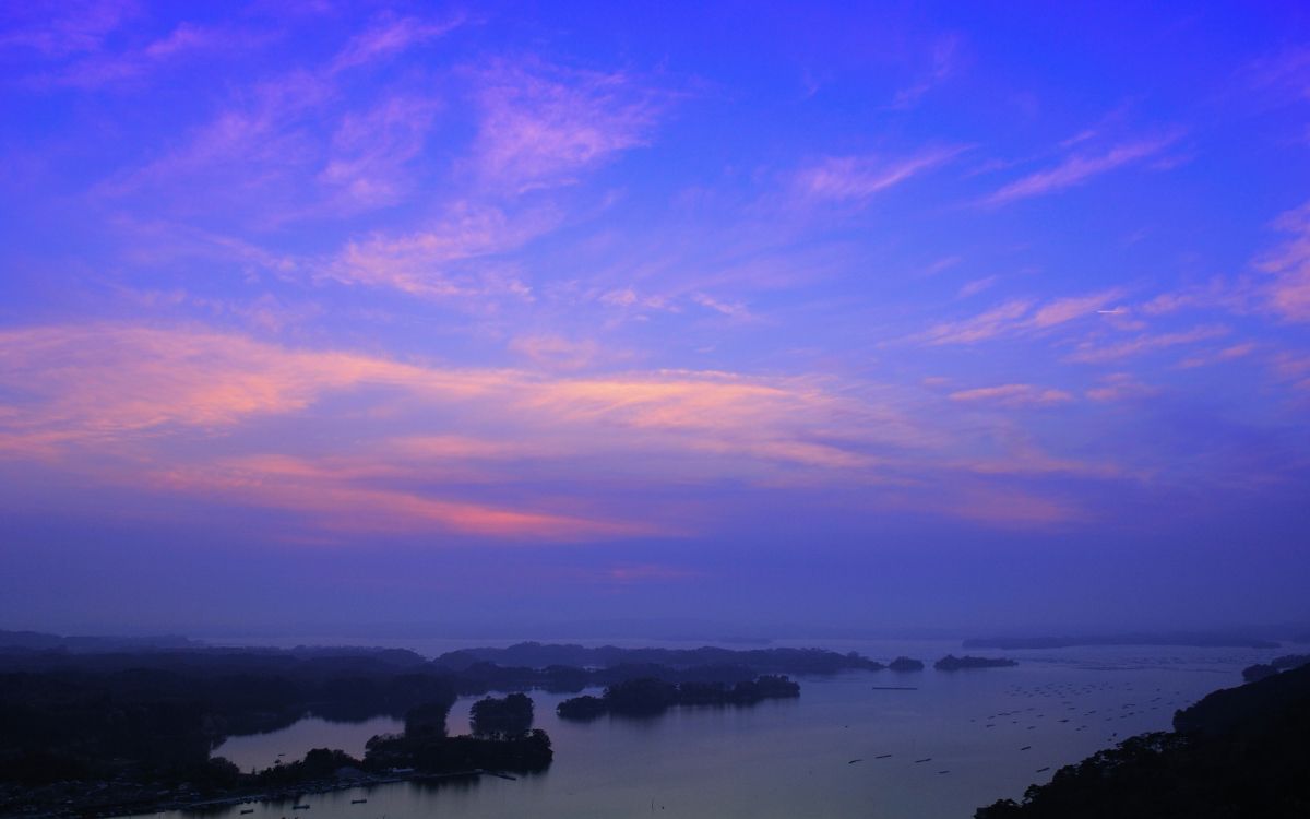 body of water under cloudy sky during sunset