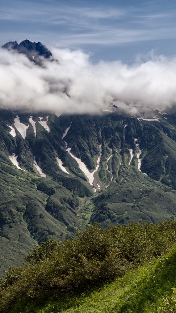 Image green grass field and mountain under white clouds during daytime