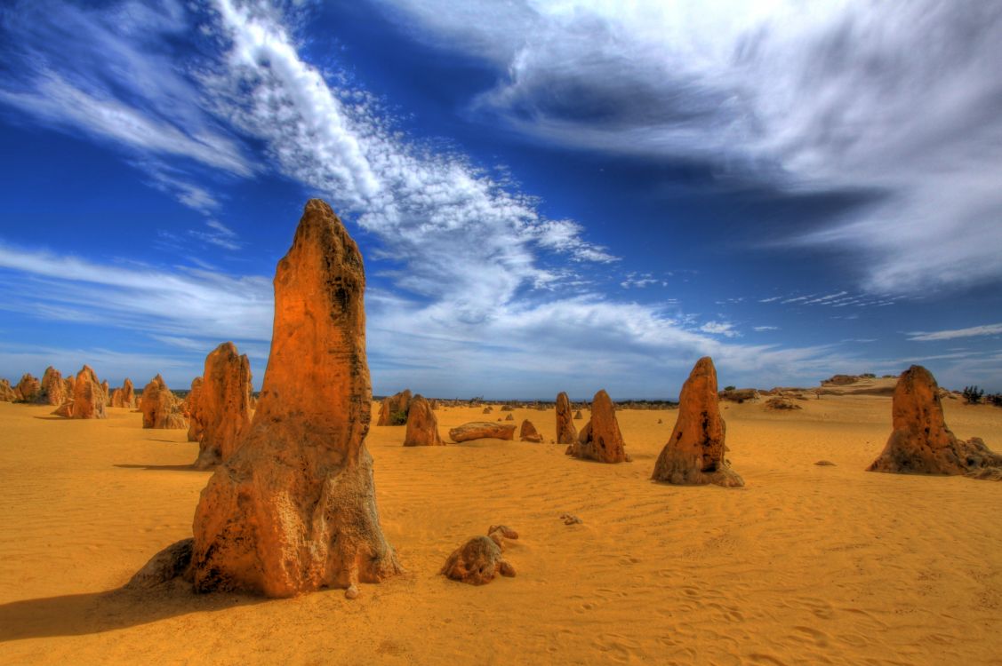 brown rock formation under blue sky and white clouds during daytime