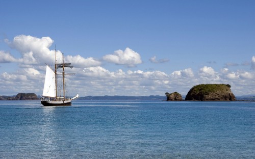 Image white and brown boat on sea under blue sky during daytime