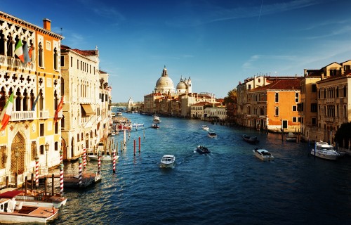 Image boats on river between buildings during daytime