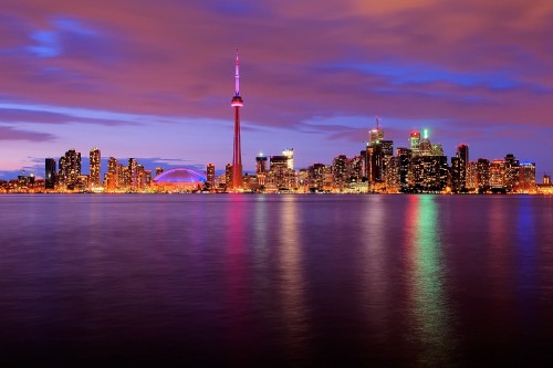 Image city skyline across body of water during night time