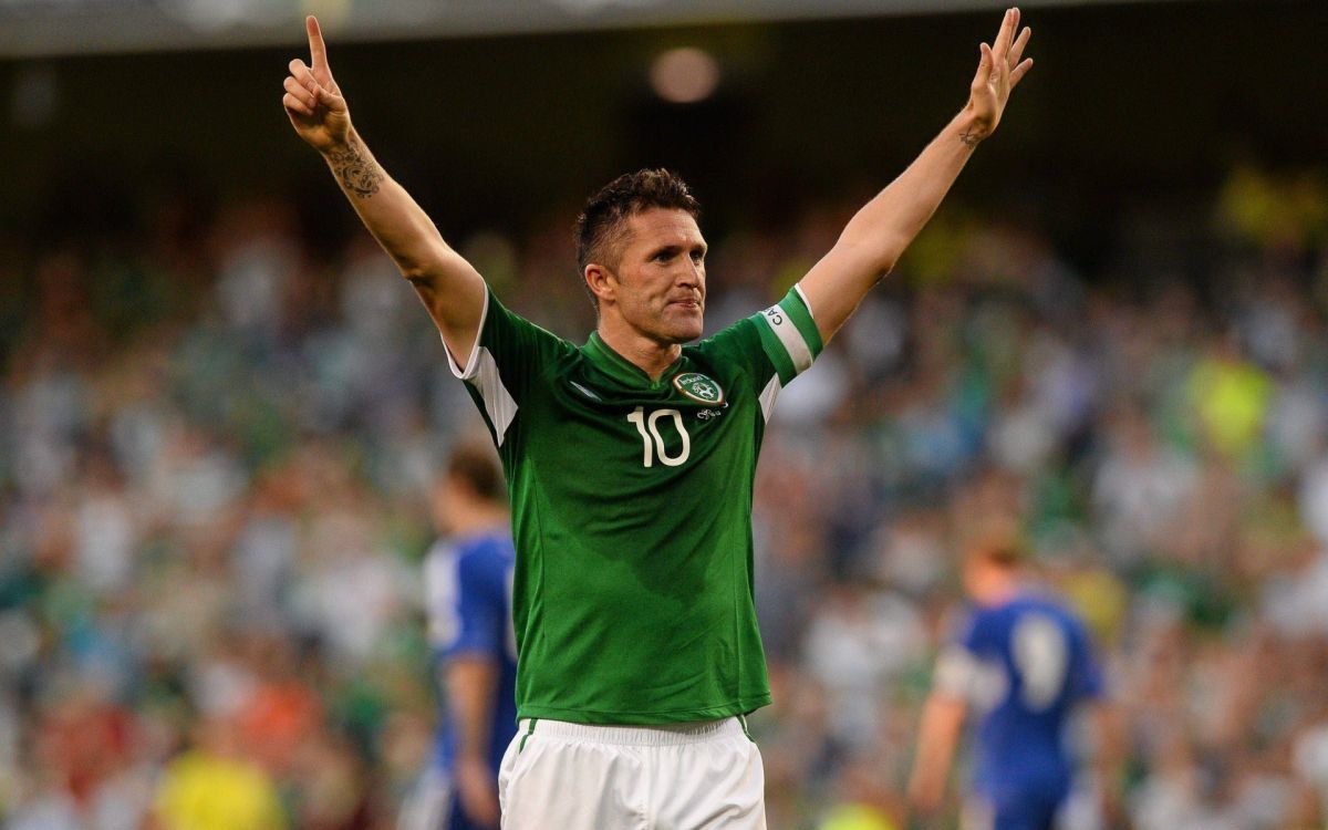 man in green and white nike soccer jersey shirt raising his right hand