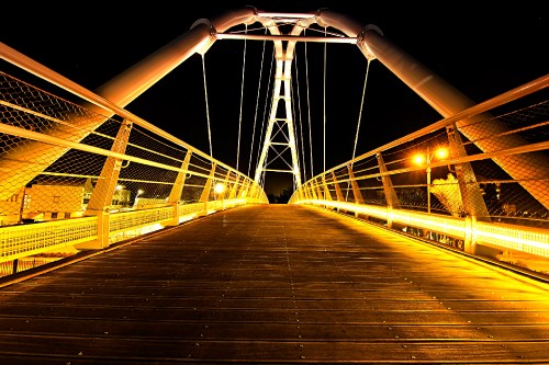 Image brown wooden bridge with light post during night time